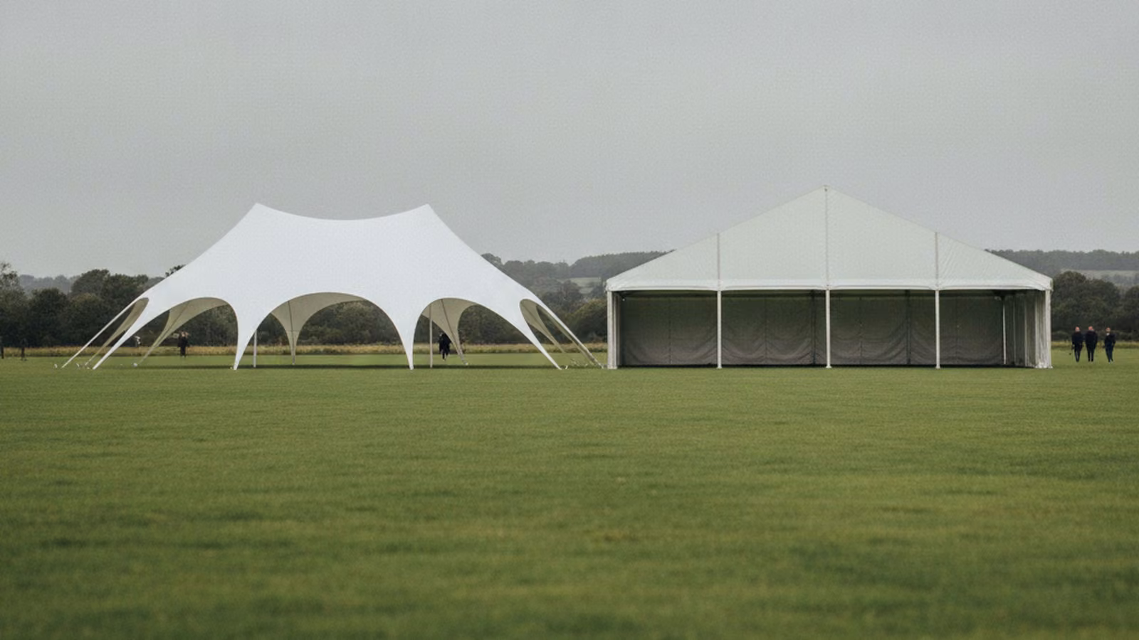 A curved stretch tent and a straight-sided framed marquee pitched side by side