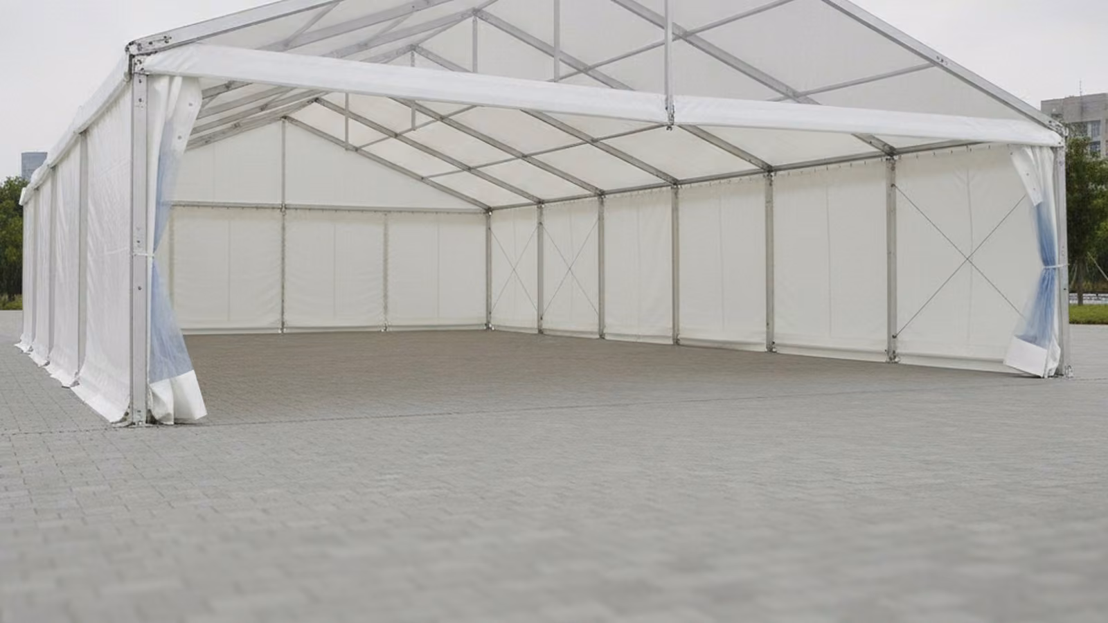 White aluminium framed event tent erected on a paved surface
