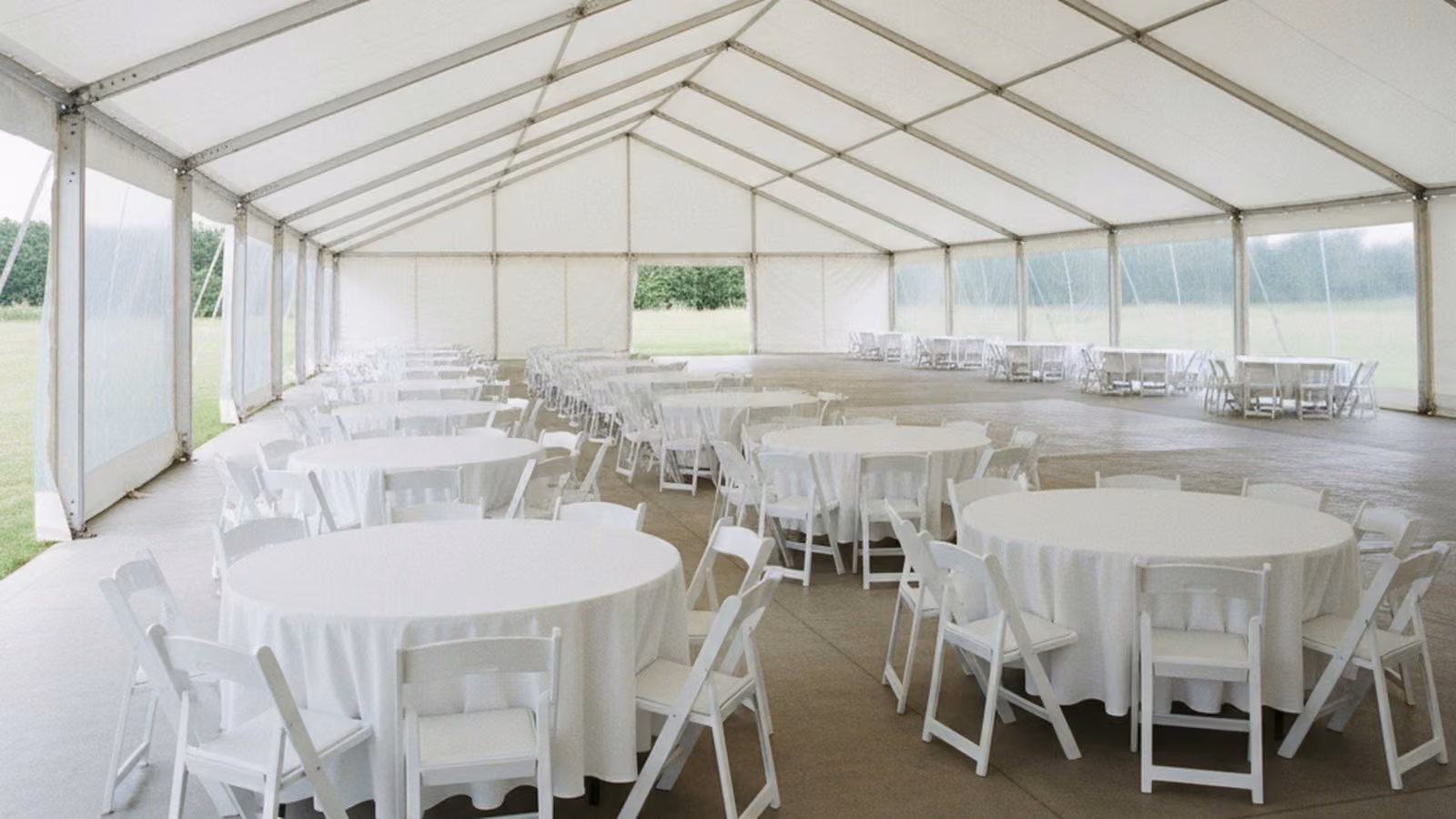 An empty marquee interior with round banquet tables spaced across the floor